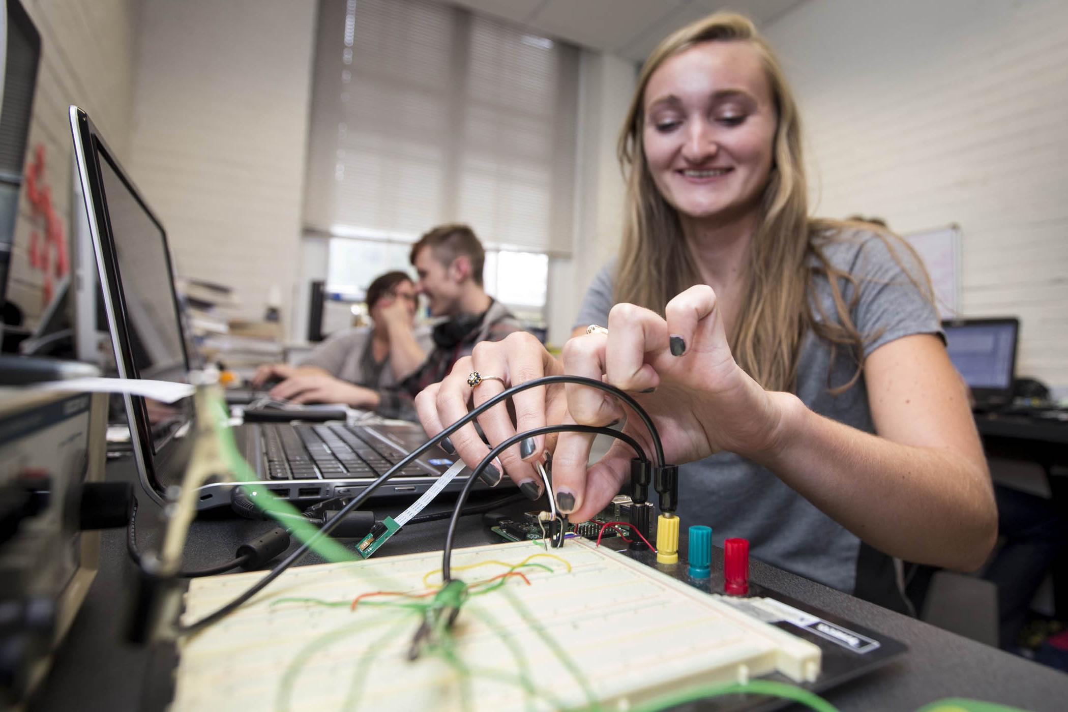 Student checks electrical connections on instruments